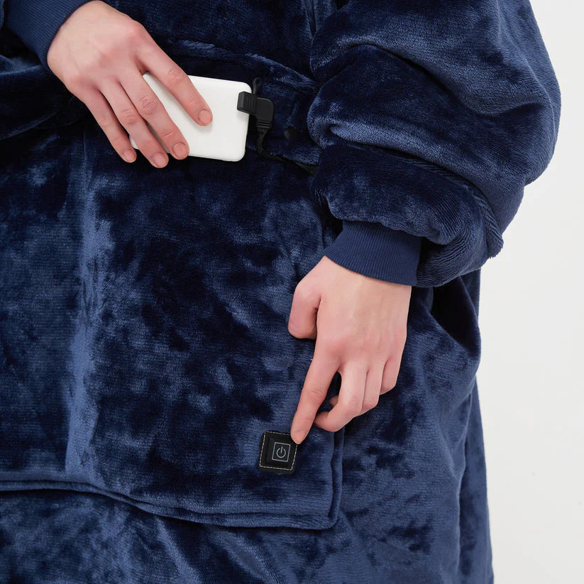 Power bank connected inside the front pocket of a navy heated hoodie blanket, next to the pocket power button